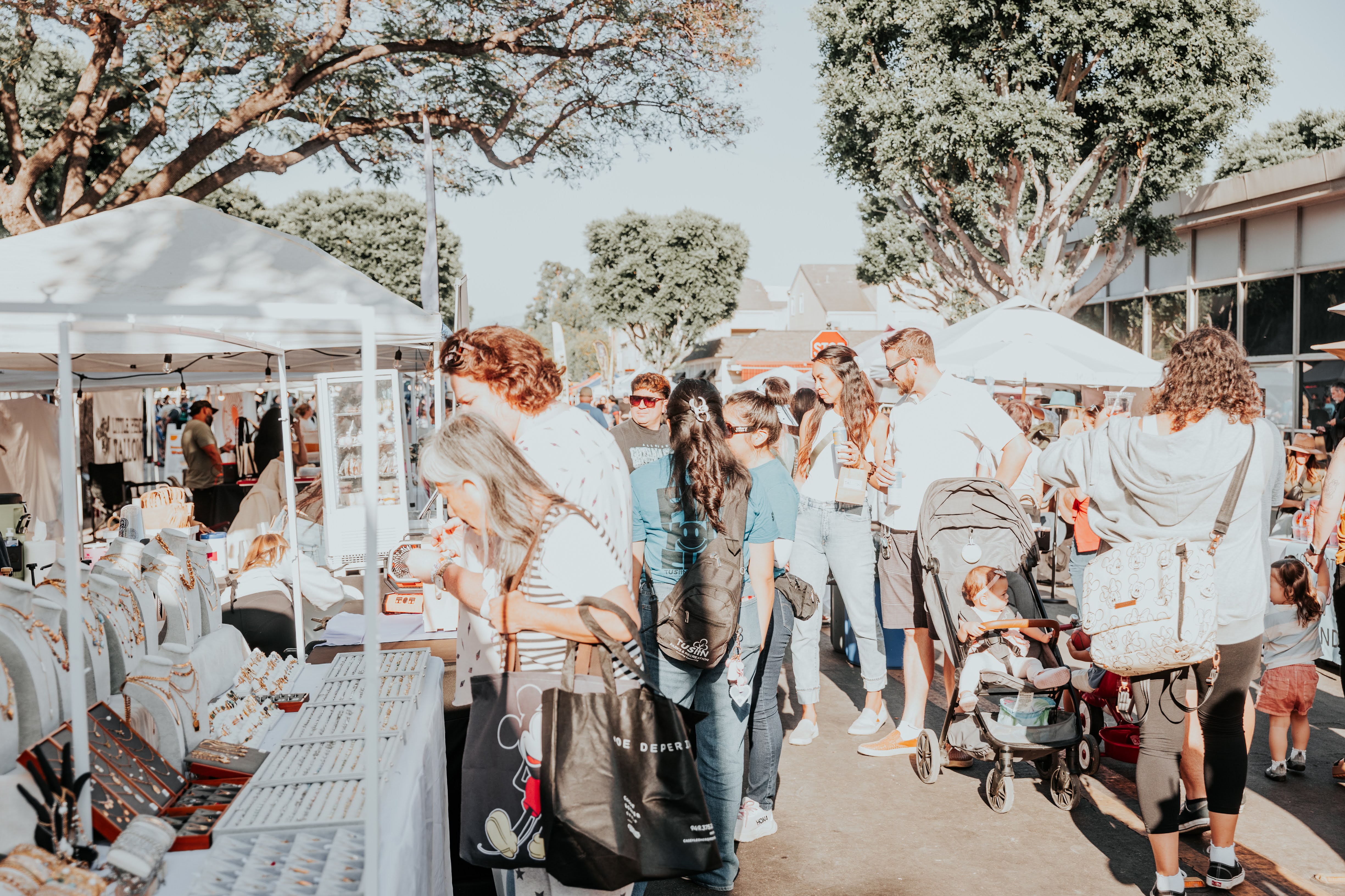 Crowd at a jewelry booth with stroller